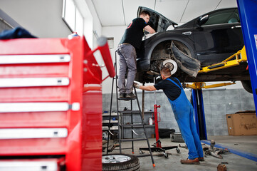 Car repair and maintenance theme. Mechanic in uniform working in auto service.