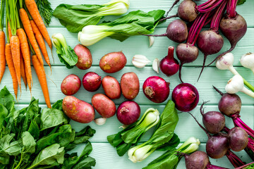 Carrot, potato, beet, onion and spinach on green background top view