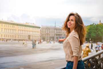 A happy Young woman walks through the historic streets of Saint Petersburg in the center of the city in summer