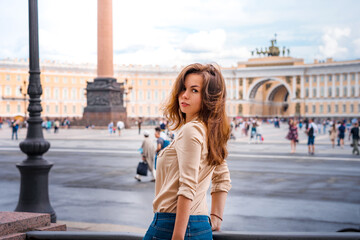 Obraz premium A beautiful woman with long hair visits the tourist city of Saint Petersburg while staying at the main attraction on the Palace square in the center