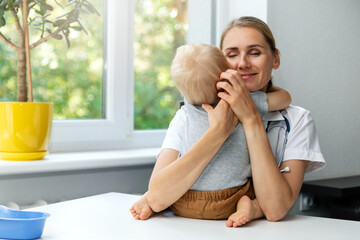 friendly pleasant pediatrician hugs child patient in clinic office. empathy and love your job concept