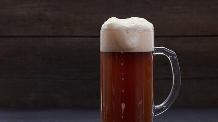 Pouring beer into a glass on a wooden background