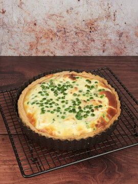 Homemade quiche with smoked trout, goat cheese and green peas