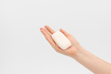 Naklejka premium Bar of white soap in a woman's hand.