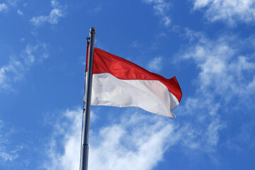 Indonesian flag isolated on blue background.