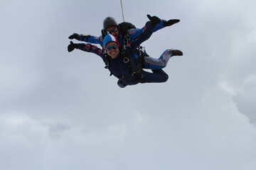 Fototapeta na wymiar Skydiving. Two guys are flying and having fun in the sky.