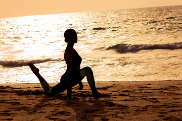 young woman doing yoga on the beach