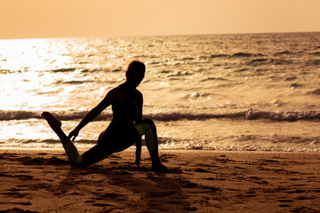 young woman doing yoga on the beach