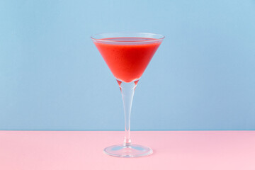 Strawberry smoothie cup on a pink and light blue background