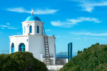 A small blue roofed church by the sea