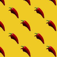 Colorful seamless pattern with red chili peppers in hard light on bright yellow background.