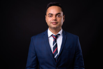 Portrait of young handsome Indian businessman in suit