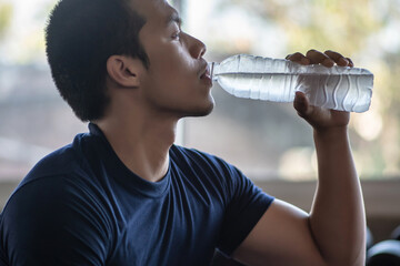 Young Man Drinking Water At Gym