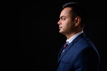 Portrait of young handsome Indian businessman in suit - 369682398