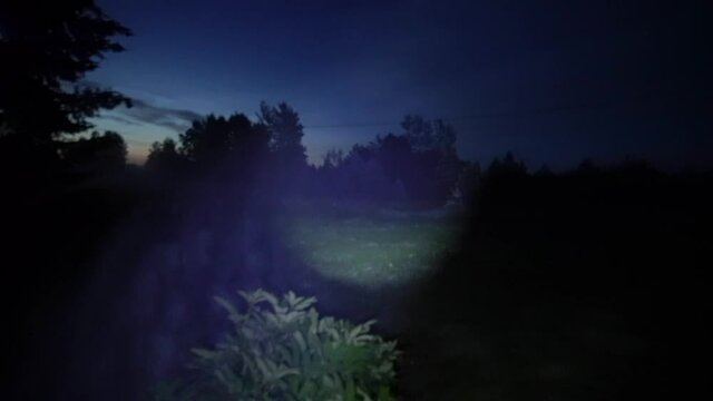A man with a flashlight walks around the house in the dark at night. Creepy.