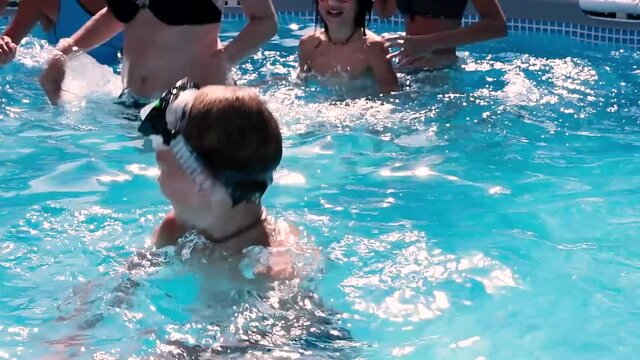 Child swimming in a swimming pool while people practicing water aerobics