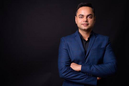 Portrait of young handsome Indian businessman in suit