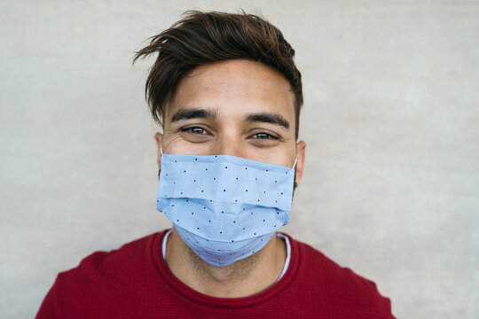 Young man wearing face mask portrait - Latin boy using protective facemask for preventing spread of corona virus - Health care and youth millennial people concept