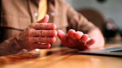 The scene of the gestures of the hands of a man next to a laptop