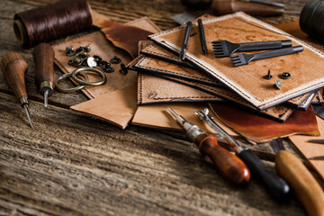 Leather craft tools on old wood table. Leather craft workshop.