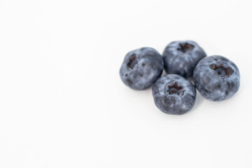 
Blueberries on a white background. And also in a glass with a yellow tube. On a gray background.