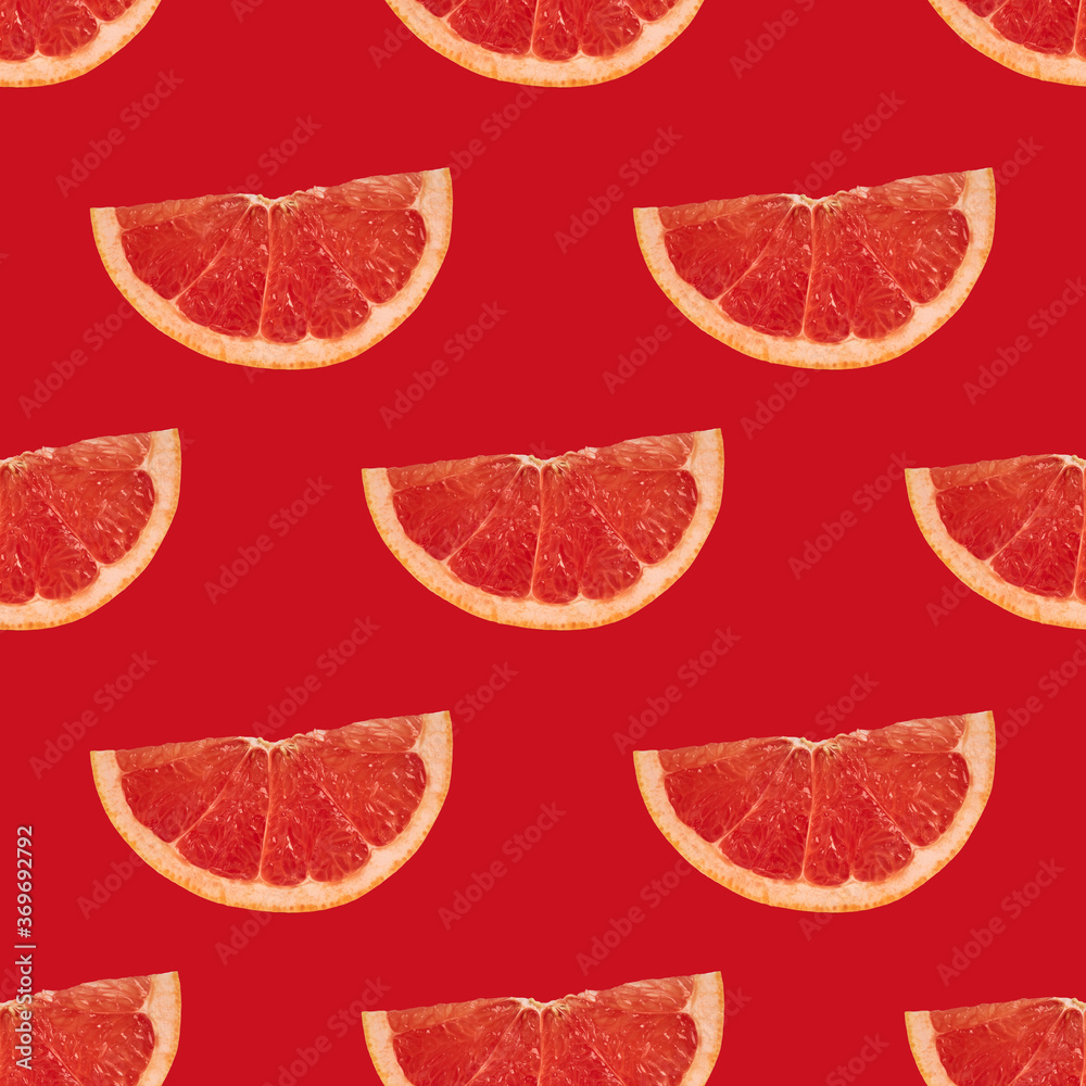 Wall mural slices of ripe grapefruit on a bright red background. geometric seamless pattern