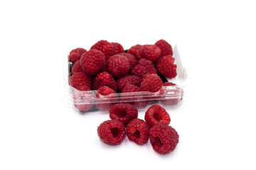 fresh raspberries in clear plastic box isolated on white background.