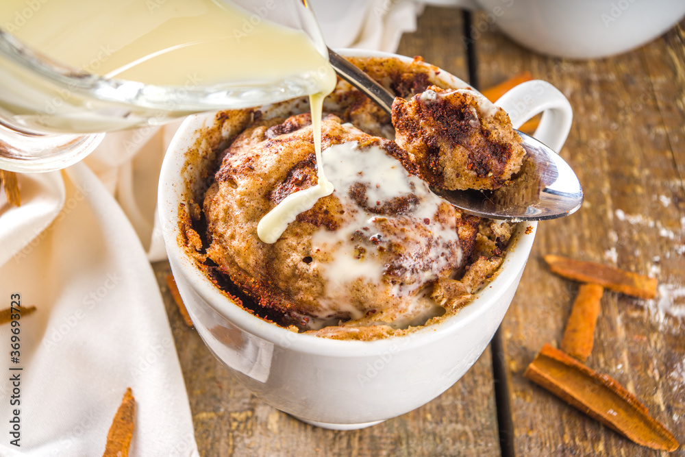 Wall mural cinnabon cake in mug. fast simple microwave dessert idea, background for recipe. cinnamon roll mugca