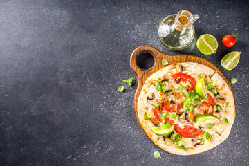 Homemade tasty pizza with seafood, tomatoes on a grey stone table