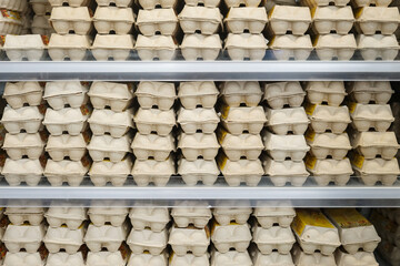 Cardboard packages with chicken eggs on a shelf in a supermarket.