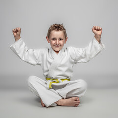 cheerful child practicing martial arts sitting on the ground