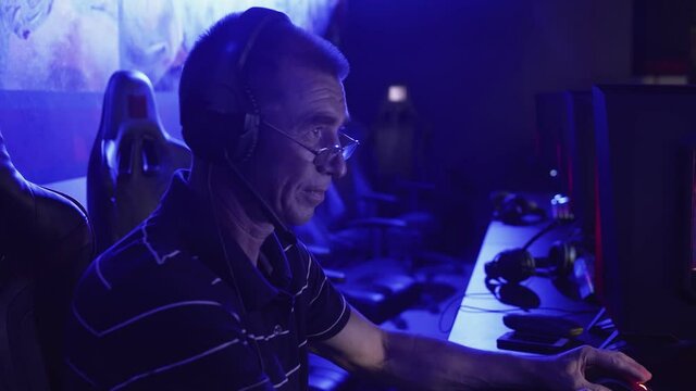 Old man gamer is emotionally playing and losing in a computer game