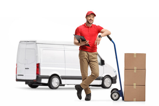 Delivery man with cardboard boxes on hand truck standing in front of a white van