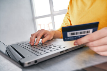 Close up shot of bank card in hand of woman. Shopping online from home
