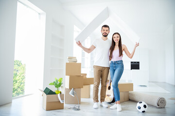 Full length body size view of his he her she nice attractive cheerful married spouses holding in hands wooden roof rent bank loan purchase building development at flat light white interior