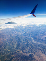 Fototapeta na wymiar plane wing snow mountain view with blue sky. Photo from Flight.