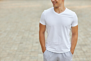 Fototapeta premium A young man in a sports uniform stands in the park.