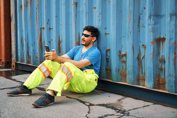 breaking time for foreman to sitting with box container and looking to mobile phone