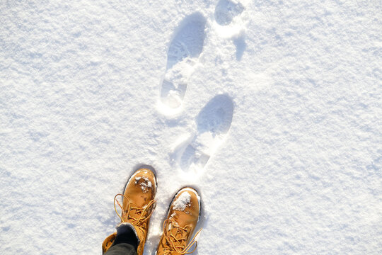 Top View Of Yellow Shoes / Boots Footprint In Fresh Snow. Winter Season. 