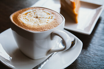Coffee cup and saucer on a wooden table, shallow DOF