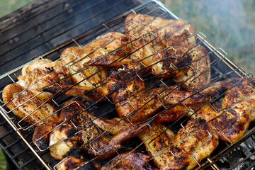 Chicken wings grilling on a summer barbecue. BBQ background.