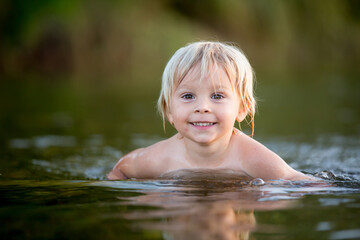 Beautiful portrait of child in lake, kid playing
