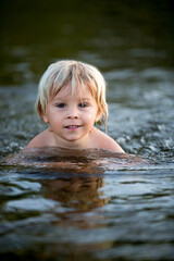 Beautiful portrait of child in lake, kid playing