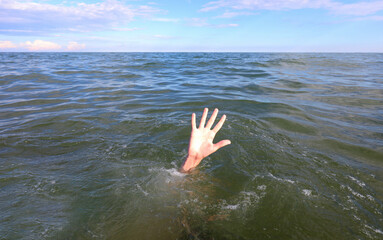 hand of the person asking for help while drowning in the sea