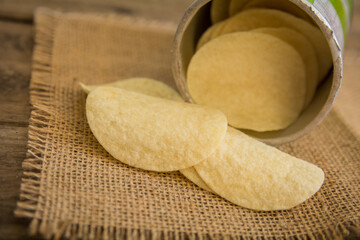 Crispy potato chips on wooden background