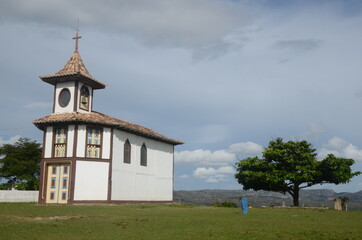 Naklejka premium Mother Church in Milho Verde/MG with green grass and blue sky at sunny day