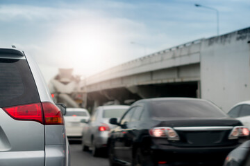 Silver car on the road in traffic junction there are many cars on the road. With different levels of roads. And the blur of the warm sky.
