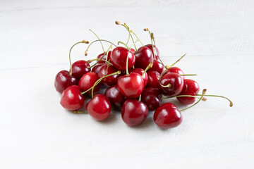 Obraz na płótnie Canvas Beautiful, fresh, juicy cherries on a white wood background.
