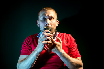 Man shaving with electric razor on dark  background
