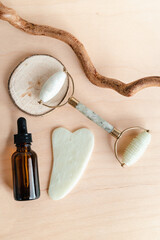 Facial massage roller and guache scraper on wood background. Advertising Beauty salon, face massage. Place for the text. Stock photography
